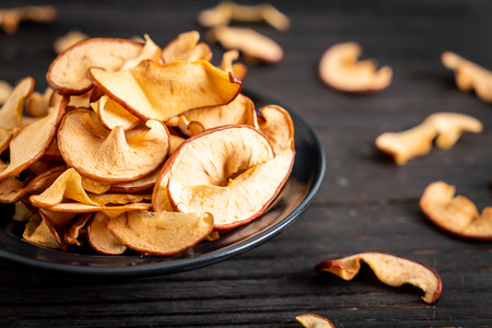Homemade dried organic apple sliced on wood background