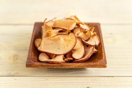 Homemade dried organic apple sliced on wood background
