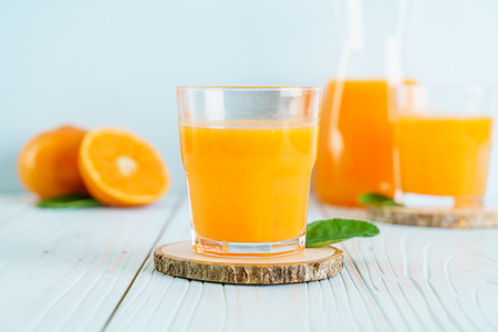Fresh orange juice on wood background - healthy drinkの写真素材
