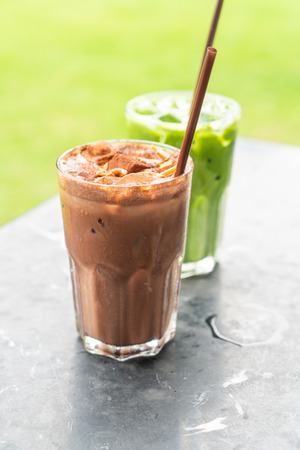iced chocolate milkshake and iced green tea with milk in restaurant and cafeの写真素材
