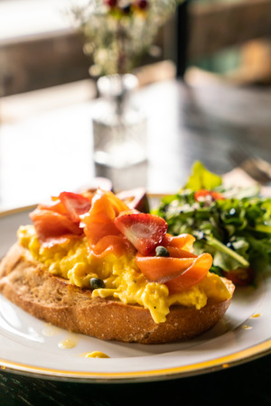 smoked salmon with crumble egg toasted with saladの写真素材