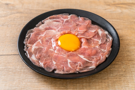 fresh sliced pork raw with egg for cooking or making shabu shabu and sukiyakiの写真素材