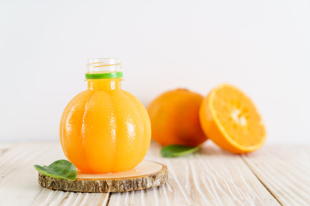 Fresh orange juice on wood background - healthy drinkの写真素材