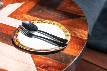 empty dish with spoon and fork on table in cafe restaurantの写真素材