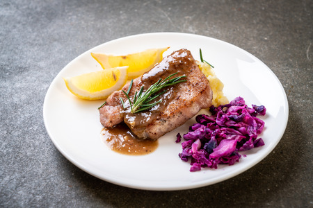 pork steak with red cabbage and mashed potatoes on white plateの写真素材