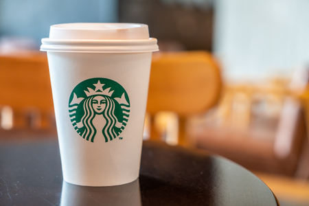 BANGKOK, THAILAND - June 29, 2018: Starbucks hot beverage coffee with holder on the table in Starbuck coffee shop.のeditorial素材