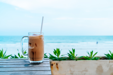 a glass of chocolate milkshake with sea view backgroundの写真素材