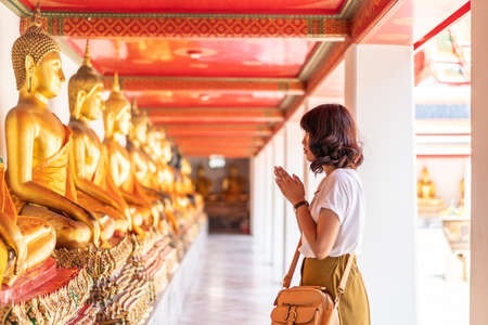 Happy Asian Woman Praying with Buddha in Temple, Thailanndの写真素材