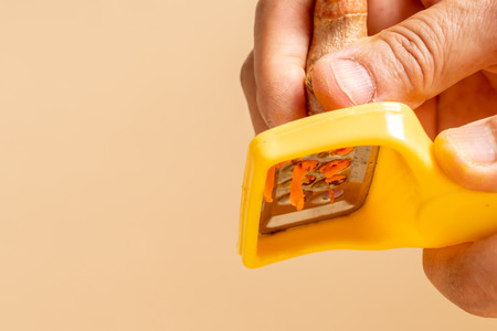 hand slicing fresh turmeric on tableの写真素材