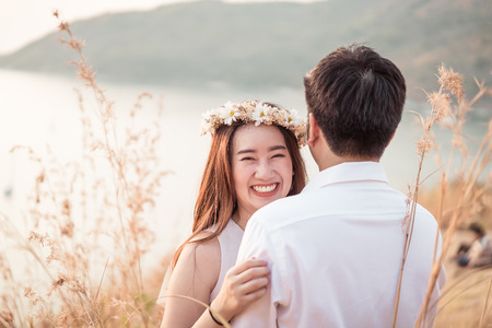 Happy young Asian couple in love having a good time with sea backgroundの写真素材