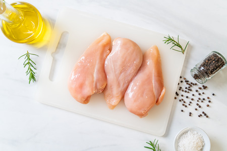 fresh chicken breast raw on cutting boardの写真素材