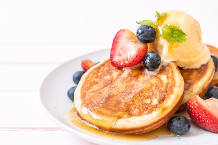 souffle pancake with blueberries, strawberries, honey and vanilla ice-creamの写真素材