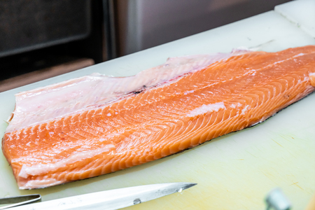 fresh raw salmon on cutting board in japanese restaurantの写真素材
