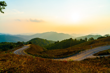 beautiful sunset sky with layer mountain and road in Thailandの写真素材