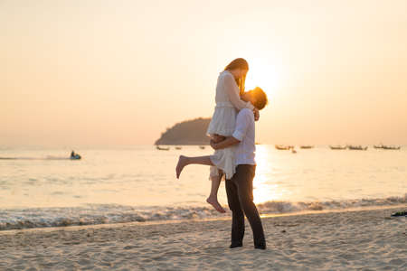 Happy Asian couple going honeymoon travel on tropical sand beach in summerの写真素材