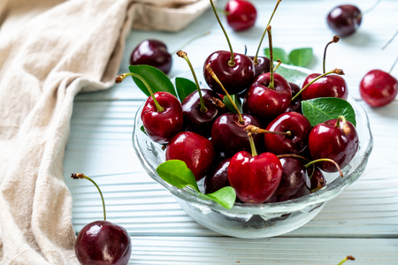 Fresh cherries in bowl  on wood backgroundの写真素材
