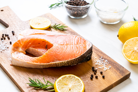 fresh raw salmon fillet steak with ingredient on boardの写真素材
