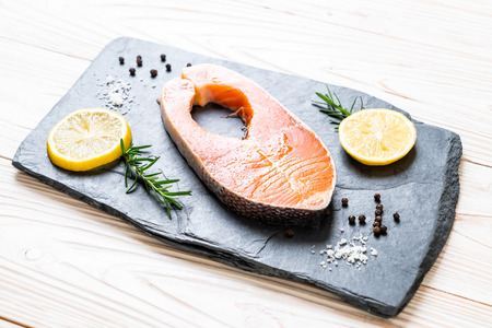 fresh raw salmon fillet steak with ingredient on boardの写真素材
