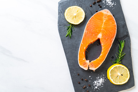 fresh raw salmon fillet steak with ingredient on boardの写真素材