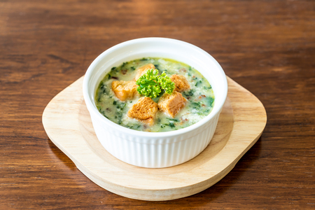 spinach soup with bread in white bowl - healthy and organic food styleの写真素材