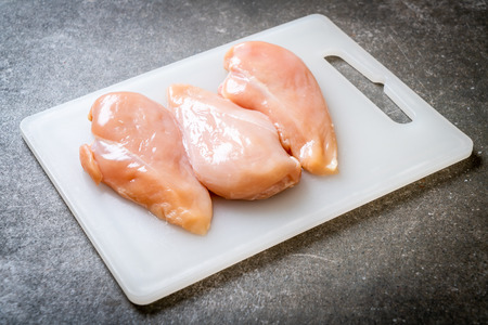 fresh chicken breast raw on cutting boardの写真素材