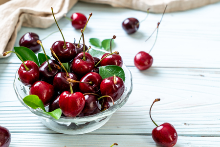 Fresh cherries in bowl  on wood backgroundの写真素材