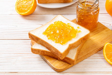 Slices of bread with orange jam for breakfastの写真素材
