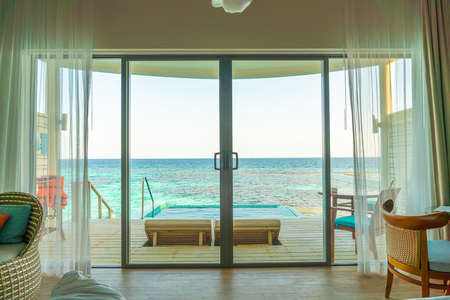 window with pool and sea background at Maldives - view from bed
