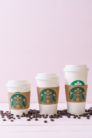 BANGKOK, THAILAND - JUN 5, 2018: White coffee cup with Starbucks logo on wood background. Starbucks is the world's largest coffee house with over 20,000 stores in 61 countries.のeditorial素材