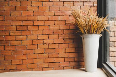 dried rice flower in vase decoration with brick wallの写真素材