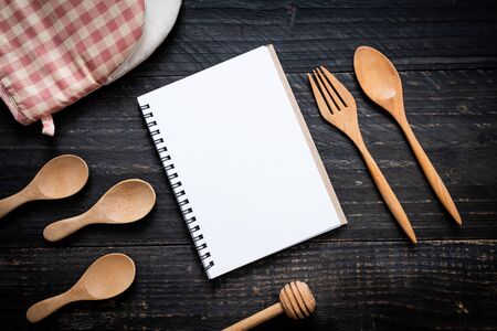 blank notebook for text note on wooden surface and wooden spoon and fork with copy spaceの写真素材