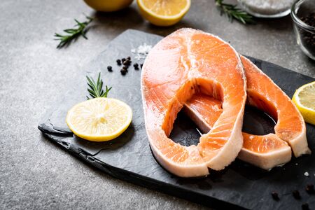 fresh raw salmon fillet steak with ingredient on boardの写真素材