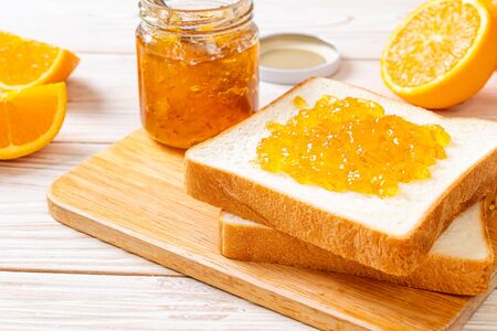 Slices of bread with orange jam for breakfastの写真素材