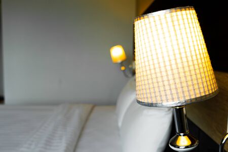shining lamp in bedroom near bedの写真素材
