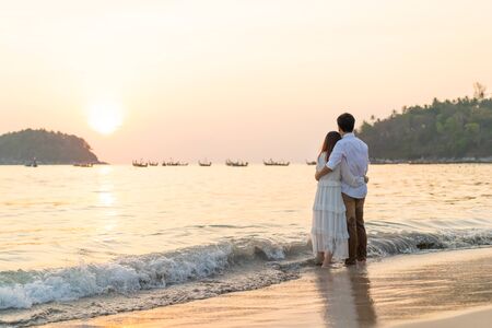 Happy Asian couple going honeymoon travel on tropical sand beach in summerの写真素材