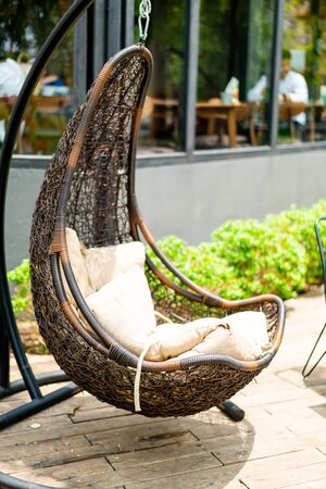 outdoor patio wicker swing chair with pillowsの写真素材