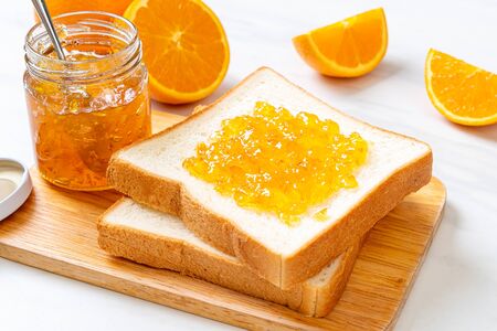 Slices of bread with orange jam for breakfastの写真素材
