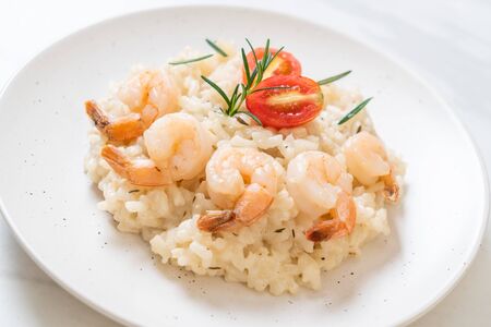 Italian risotto with shrimps on white plateの写真素材