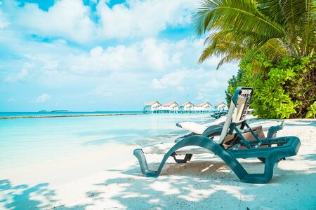 beach chair with tropical Maldives resort hotel island and sea backgroundの写真素材