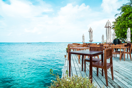 empty outdoor wood table and chair with sea view background in Maldivesのeditorial素材