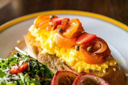smoked salmon with crumble egg toasted with saladの写真素材