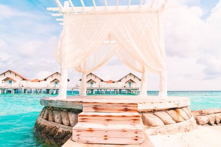 white arch with tropical Maldives resort and sea backgroundの写真素材