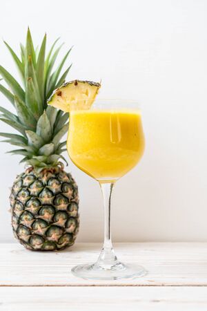fresh pineapple smoothie glass on wood table - Healthy Drinkの写真素材