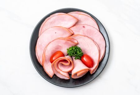 smoked ham sliced on plateの写真素材