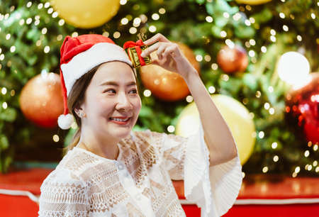 portrait of smiling beautiful young Asian woman with gift on the festive Christmas fair - vintage effect filterの写真素材