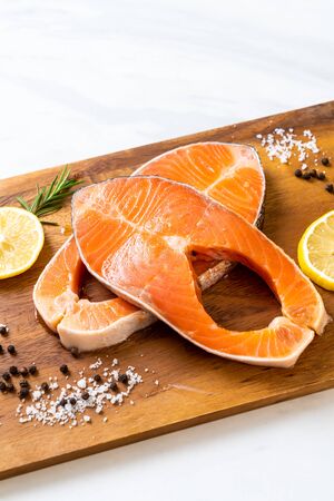 fresh raw salmon fillet steak with ingredient on boardの写真素材