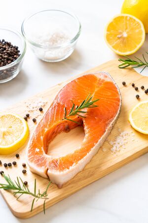 fresh raw salmon fillet steak with ingredient on boardの写真素材