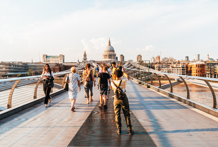 LONDON, UK, AUG 27, 2019: People are walking through Millenium bridge, St Paul's cathedral behind in Londonのeditorial素材