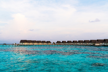 Beautiful tropical sunset over Maldives island with water bungalow in hotel resort - Vintage Filter and Boost up color Processingのeditorial素材