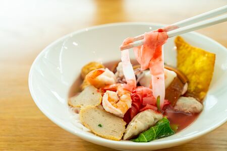 Pink seafood flat noodles (Yen Ta Fo) in white bowlの写真素材